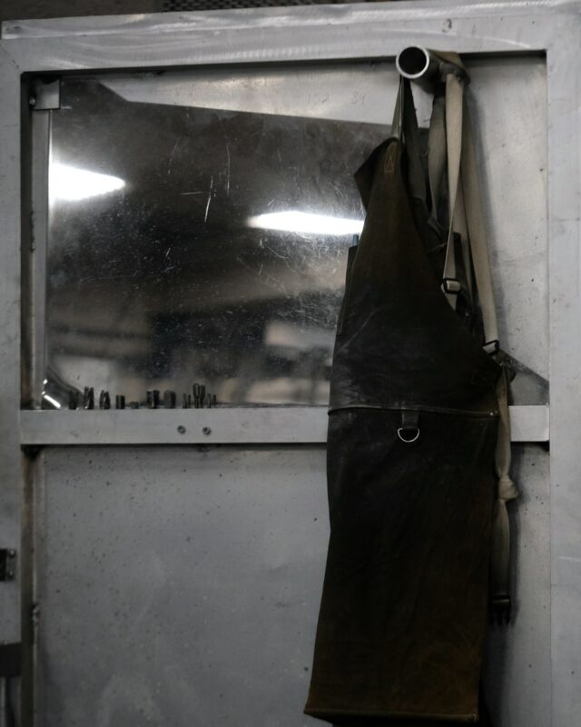 A worn leather apron hanging in a workshop