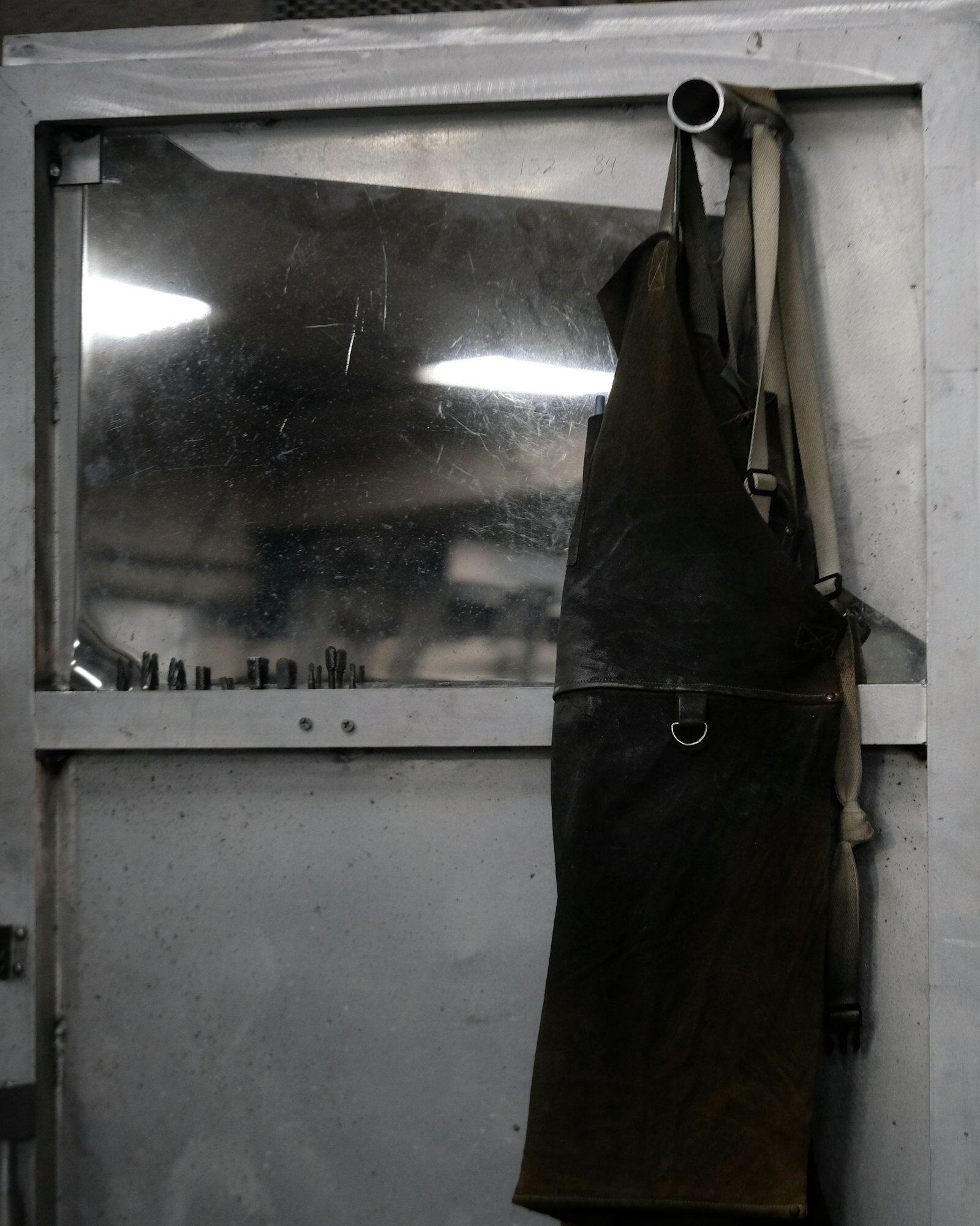 A worn leather apron hanging in a workshop