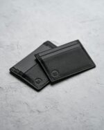 Two card holders in black on concrete