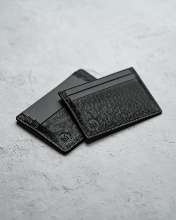 Two card holders in black on concrete
